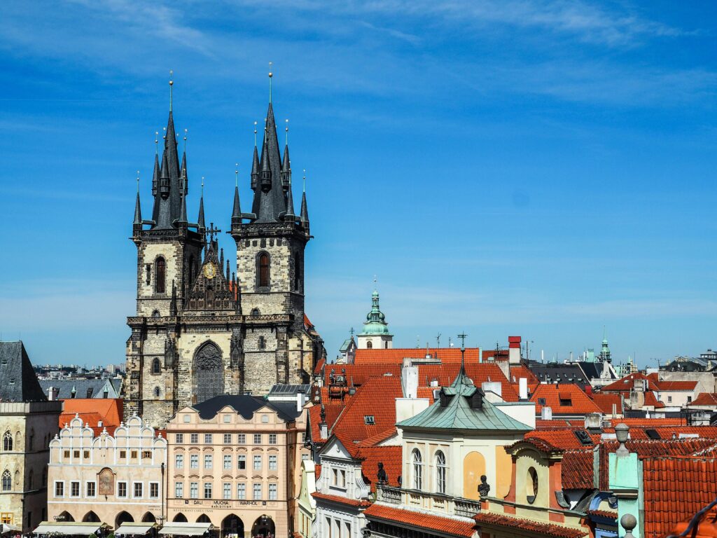 Aerial view of the Church of Our Lady Before Tyn and colorful rooftops in Prague's cityscape.