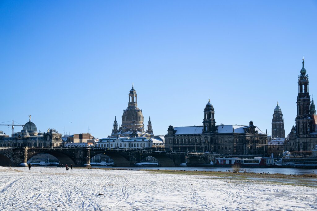 Winter scene of Dresden's architecture with snow and a clear blue sky, showcasing the city's skyline.